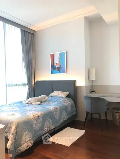 Bright and cozy bedroom with modern decor and large window for natural light.