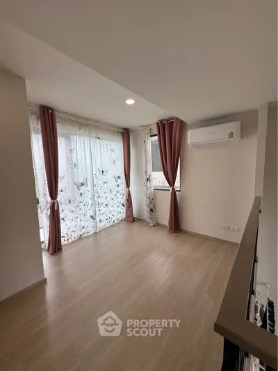 Spacious living room with elegant curtains and natural light, featuring modern air conditioning.