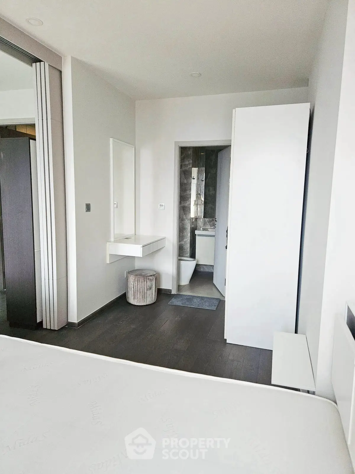 Modern bedroom with ensuite bathroom featuring sleek design and minimalist decor.