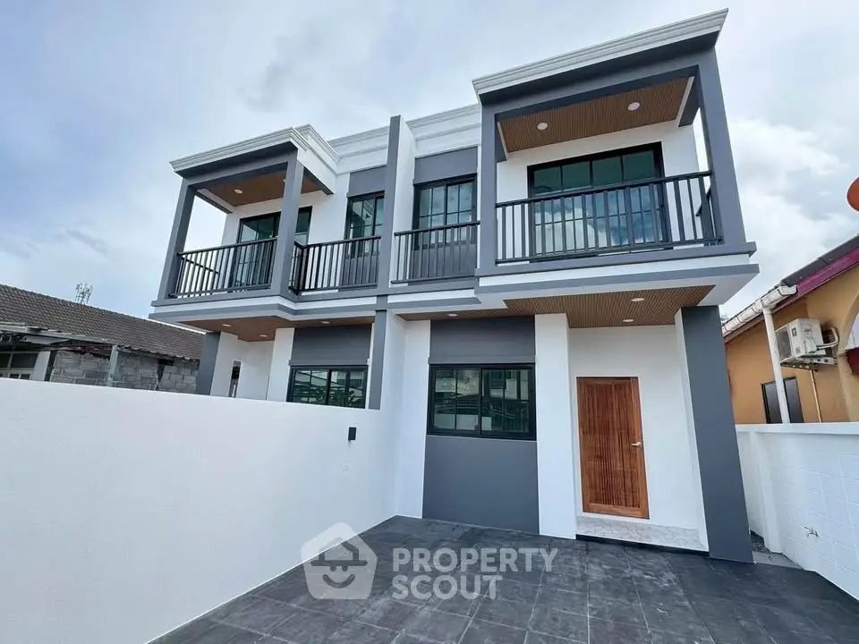 Modern two-story house with sleek design and spacious balcony, perfect for contemporary living.