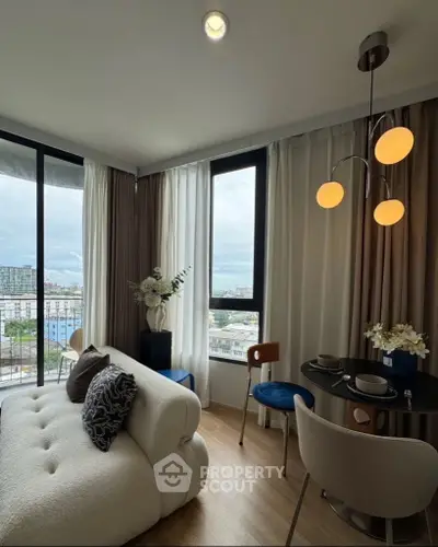 Modern living room with stylish furniture and city view, featuring elegant lighting and cozy seating area.