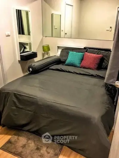 Cozy bedroom with modern decor and stylish bedding in a compact space.