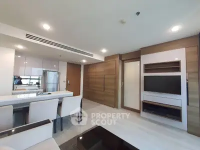 Modern living room with sleek furniture and open kitchen layout in a stylish apartment.