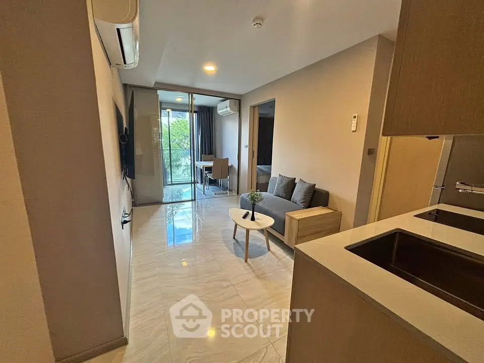 Modern apartment interior with open layout, stylish living area, and balcony view.
