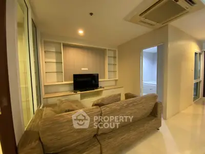 Cozy living room with modern sofa and built-in shelves, perfect for relaxation.