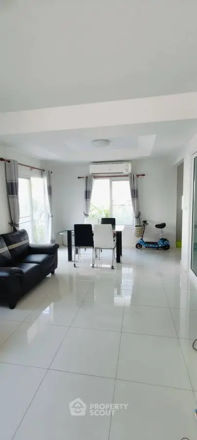 Spacious modern living room with sleek furniture and large windows.