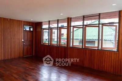 Spacious wooden interior with large windows and polished floors