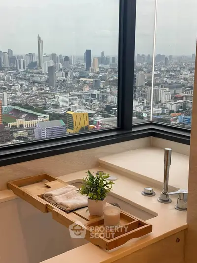 Luxurious bathroom with stunning city view from high-rise apartment window.