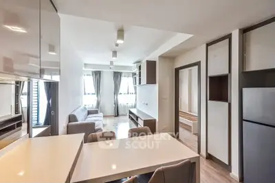 Modern open-plan living room with sleek kitchen and natural light