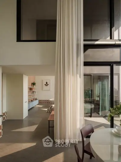 Elegant modern living room with high ceilings and floor-to-ceiling curtains, showcasing a stylish open layout.