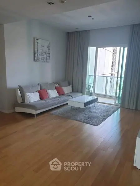 Spacious living room with modern decor and balcony access