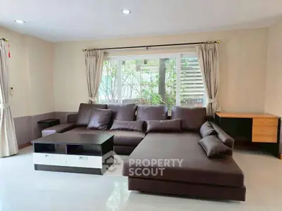 Spacious living room with modern sectional sofa and large window view