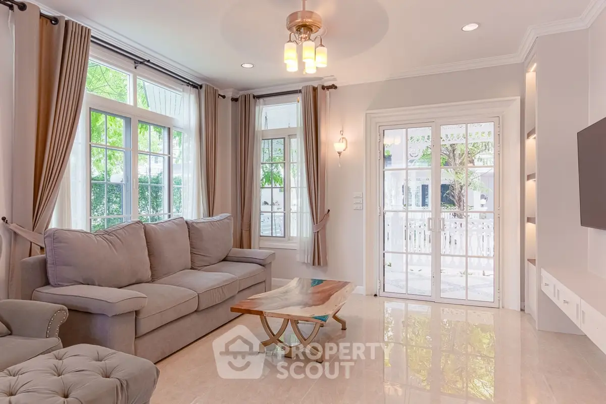 Elegant living room with plush sofa, large windows, and stylish decor in a bright, inviting space.
