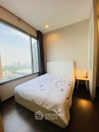 Cozy bedroom with city view, featuring a comfortable bed and modern decor, perfect for urban living.