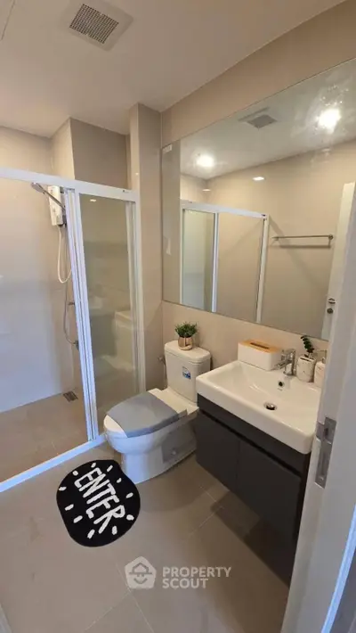 Modern bathroom with glass shower, sleek vanity, and stylish decor