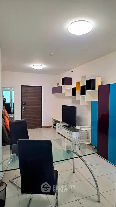 Modern living room with stylish shelving and glass dining table in a contemporary apartment.