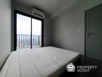 Modern bedroom with balcony and city view, featuring minimalist design and natural light.