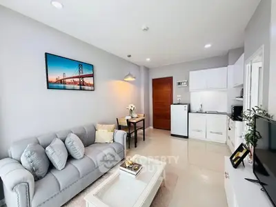 Modern living room with cozy sofa and open kitchen layout in bright apartment.