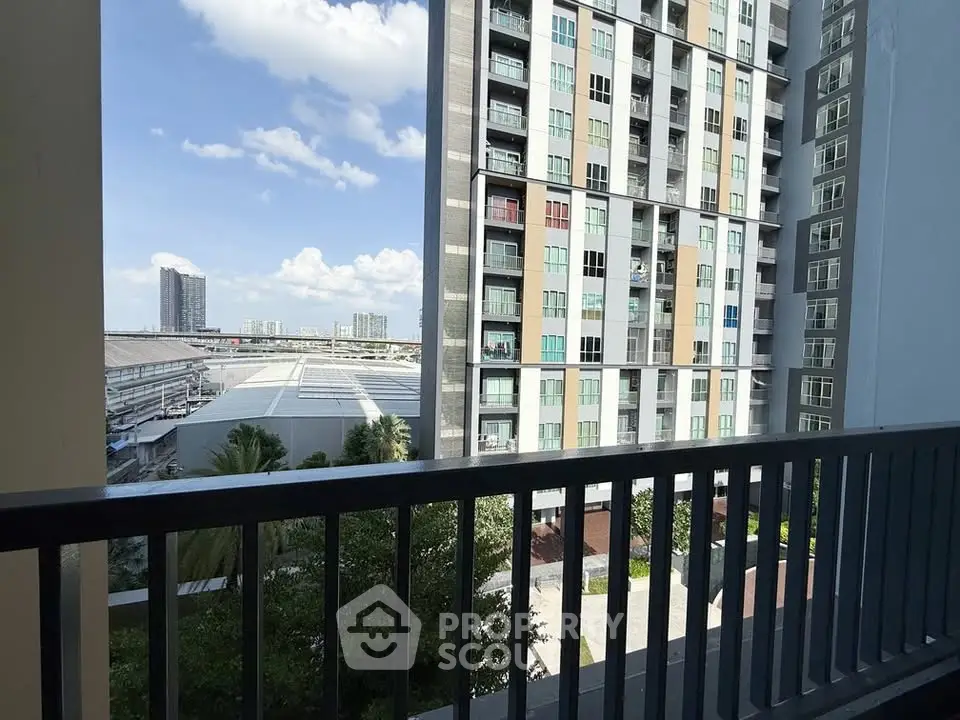 Modern high-rise building view from balcony with cityscape in background, perfect for urban living.