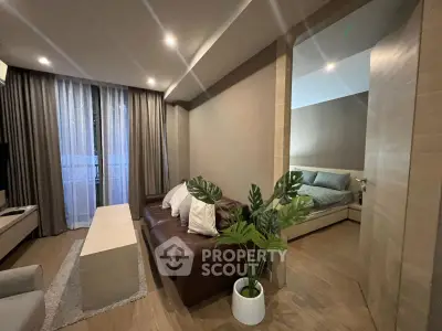 Modern living room with cozy seating and elegant bedroom view