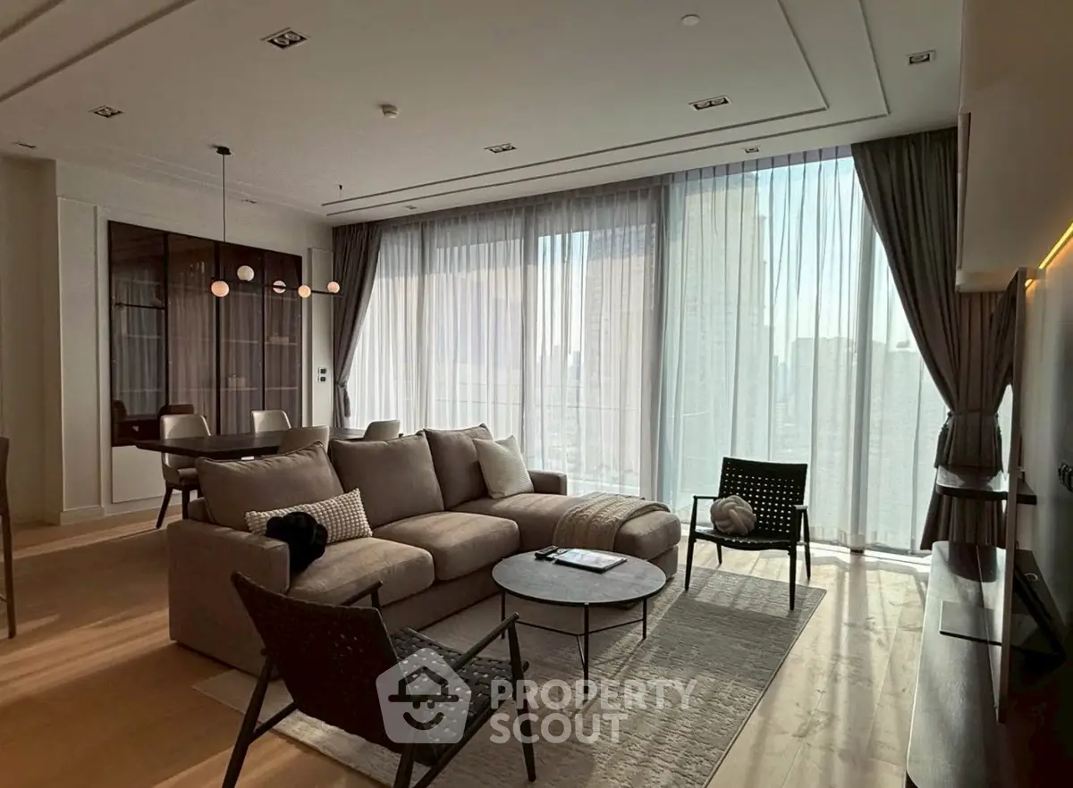Luxurious modern living room with floor-to-ceiling windows and elegant furnishings.