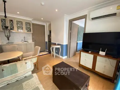 Charming living room with vintage decor, open kitchen, and modern amenities in cozy apartment.