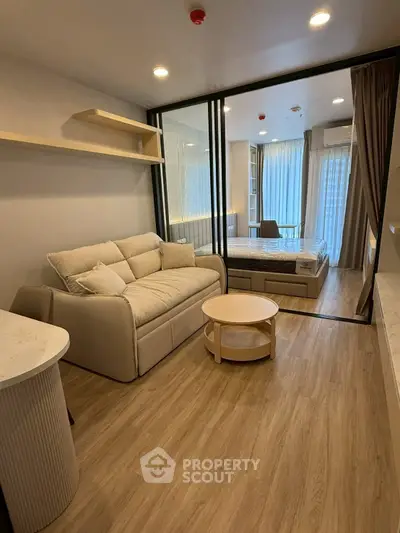Modern studio apartment with cozy living area and stylish bedroom, featuring wooden flooring and elegant decor.