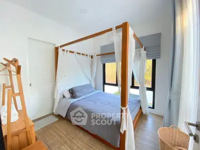 Charming bedroom with canopy bed and natural light, perfect for relaxation and comfort.