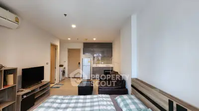 Modern studio apartment with open layout, featuring a cozy bed, compact kitchen, and stylish living area.