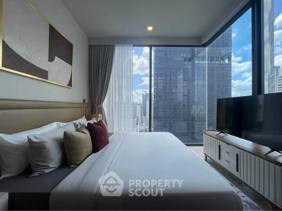 Luxurious bedroom with stunning city view and modern decor in high-rise apartment.