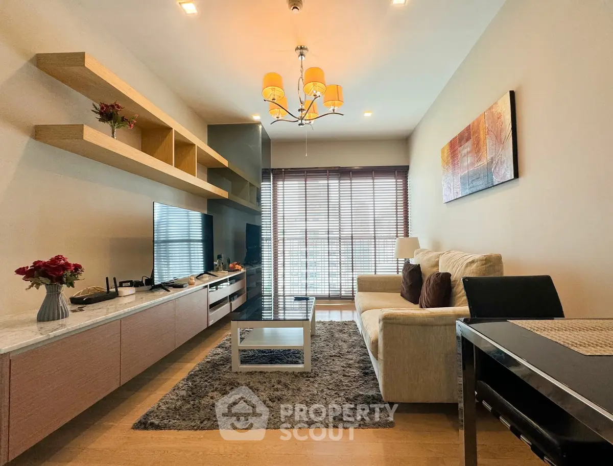 Modern living room with stylish decor and natural light, featuring a cozy sofa and elegant shelving.