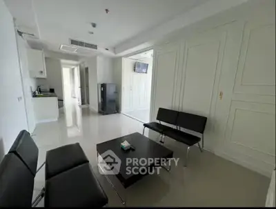 Spacious modern living room with sleek furniture and open kitchen layout.