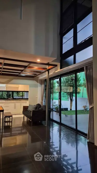 Spacious modern living room with floor-to-ceiling windows and garden view