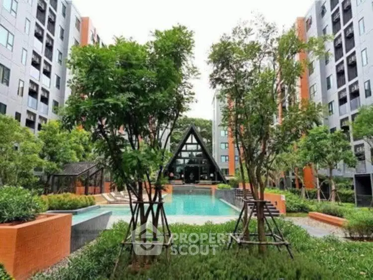 Modern apartment complex with lush garden and inviting pool area.