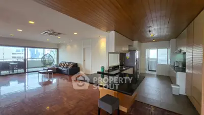 Spacious open-plan living room with modern kitchen and city view balcony.