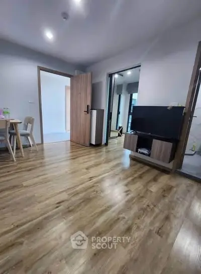 Modern living room with wooden flooring and sleek furniture in a stylish apartment.