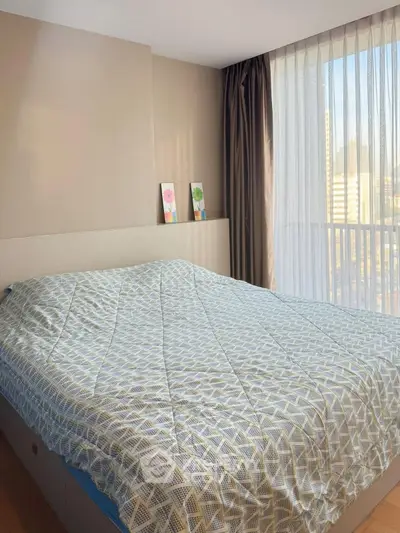 Spacious bedroom with large window offering city view, featuring modern decor and natural light.