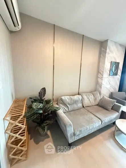 Modern living room with stylish sofa and indoor plant, featuring elegant decor and natural light.