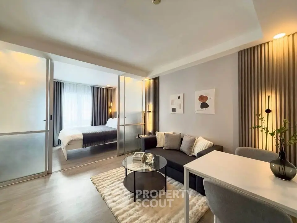 Modern open-plan living room with stylish decor and cozy bedroom area