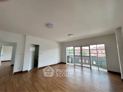Spacious empty living room with large windows and wooden flooring