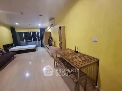 Spacious studio apartment with modern furnishings and city view, featuring a cozy bed and ample storage space.