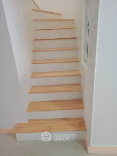 Modern wooden staircase with sleek design in contemporary home interior.