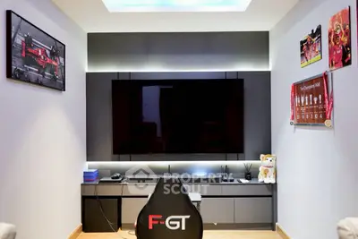 Modern entertainment room with sleek TV setup and gaming chair, perfect for relaxation and gaming enthusiasts.