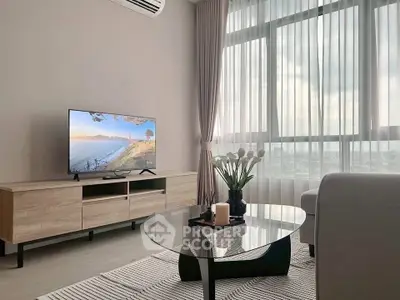 Modern living room with large window, stylish furniture, and a flat-screen TV, perfect for relaxation.