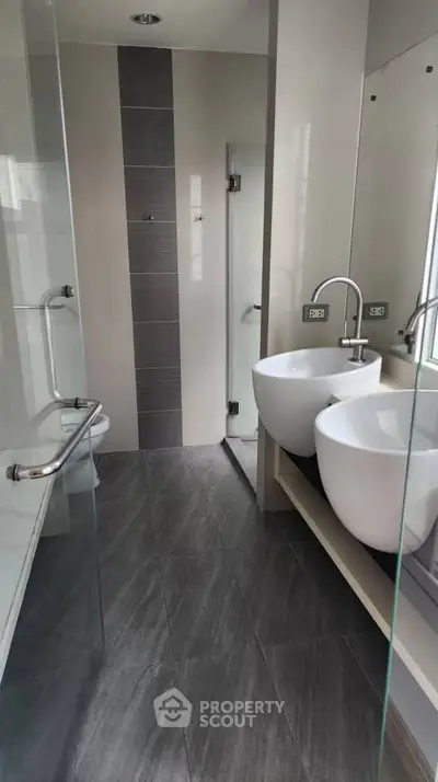 Modern bathroom with dual sinks and glass shower enclosure