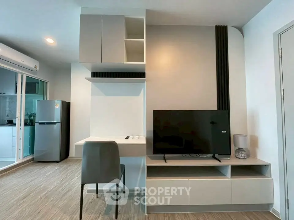 Modern living room with sleek TV unit and adjacent kitchen area