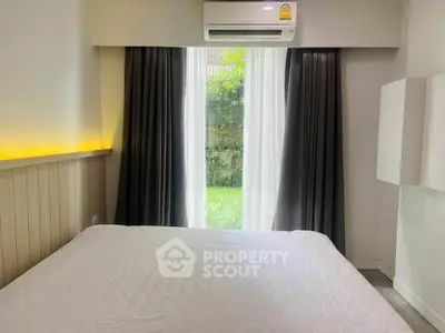 Cozy bedroom with garden view and modern air conditioning unit.