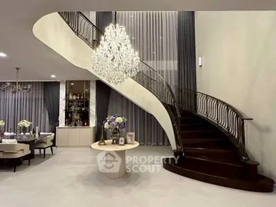Luxurious living room with elegant staircase and chandelier