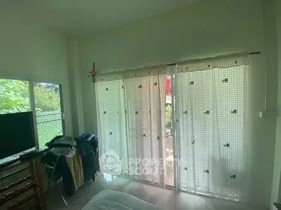 Cozy bedroom with large windows and garden view, perfect for relaxation.