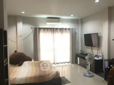 Spacious bedroom with modern decor and large window for natural light
